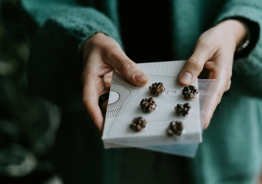 hands holding a microdosing sheet withh 1gr in each space