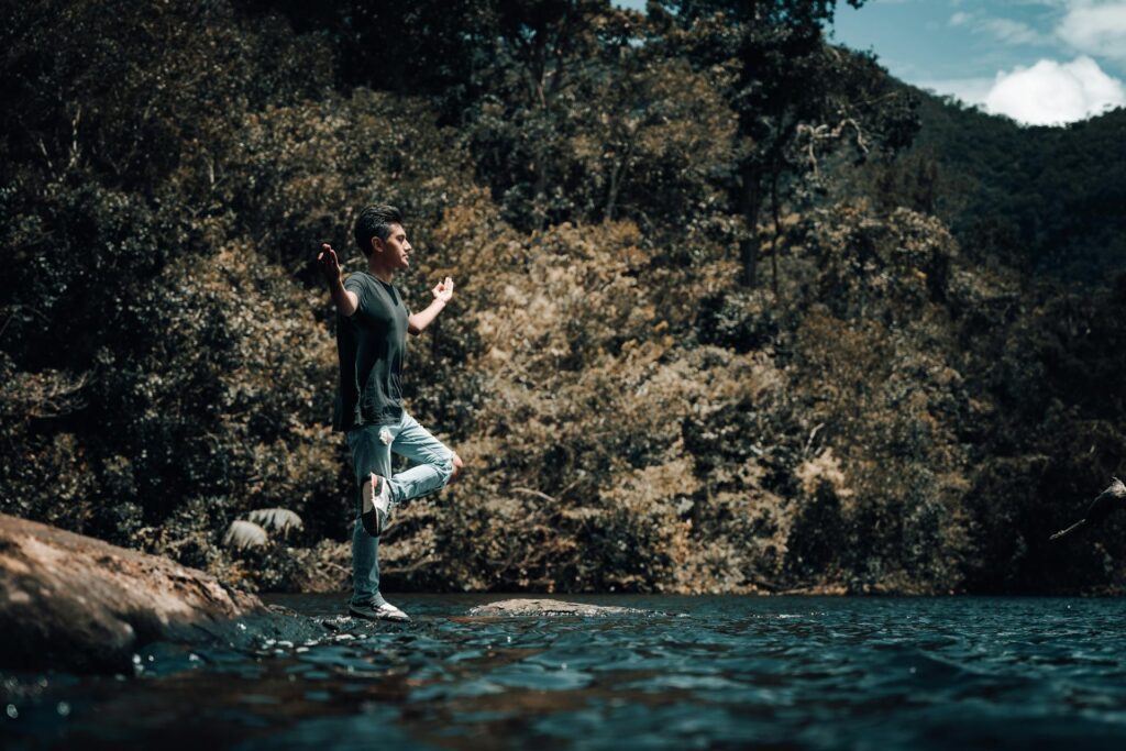 Man balancerend bij water. Hij is in balans.